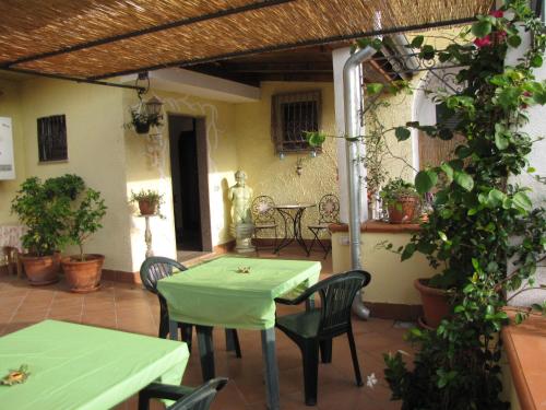 un patio con una mesa verde y sillas en B&B Moscani, en Salerno