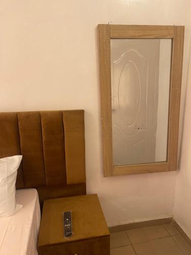 a mirror on a wall next to a bed with a table at Mph mini in Lagos