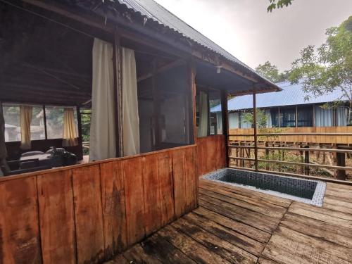 uma casa de madeira com uma piscina num deque de madeira em Amazing Lodge Perú em Iquitos