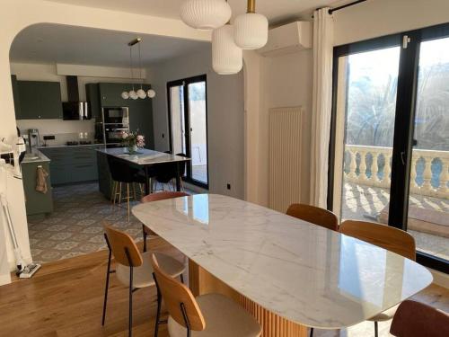 a kitchen and dining room with a white table and chairs at Maison 160m2 à 15 min de PARIS/accord arena bercy in Maisons-Alfort