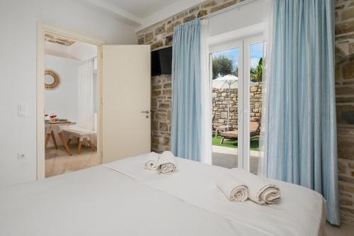 Un dormitorio con una cama blanca con toallas. en Aphrodites Luxury pearls 1, en Pitsidia