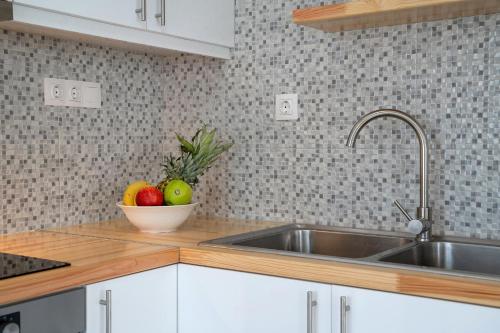 una cocina con fregadero y un bol de fruta en Aphrodites Luxury pearls 1, en Pitsidia