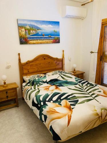 a bedroom with a bed with a floral bedspread at CasasQuesada in Ciudad Quesada