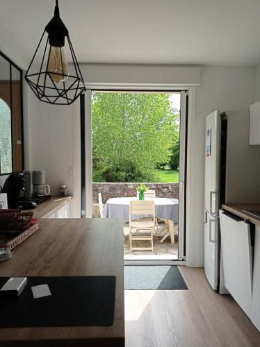 普萊納瓦昂德雷的住宿－Résidence -pleneuf Val Andre - Maisons & Villas 494，客厅设有带桌子和滑动玻璃门的厨房