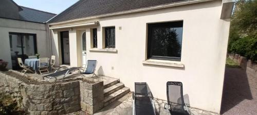 uma casa branca com cadeiras e uma parede de pedra em Résidence -pleneuf Val Andre - Maisons & Villas 494 em Pléneuf-Val-André