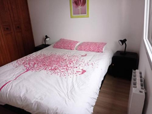 um quarto com uma cama com flores cor-de-rosa em Résidence -pleneuf Val Andre - Maisons & Villas 494 em Pléneuf-Val-André