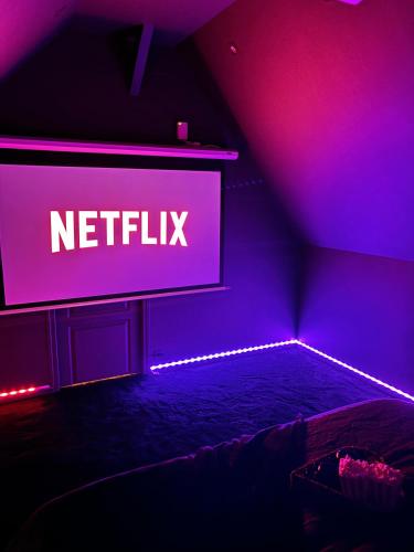 a neon sign in a dark room with a bed at Magnifique Duplex avec Jaccuzi, Sauna et Cinema Room Privatif in Fontenoy