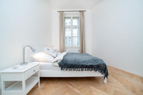 Habitación blanca con cama y ventana en Quiet apartment in the Old Town, en Praga