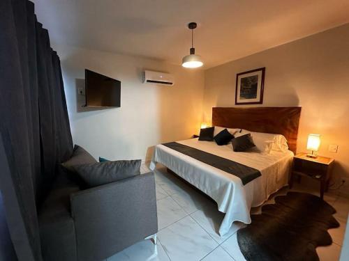 een slaapkamer met een bed en een bank erin bij Alpha D7 in Puerto Vallarta