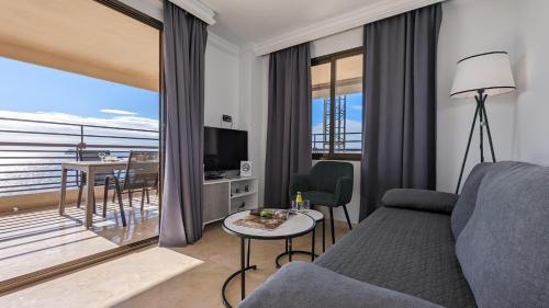 a living room with a couch and a table and a balcony at LAS ARENAS superior seafront in Benidorm
