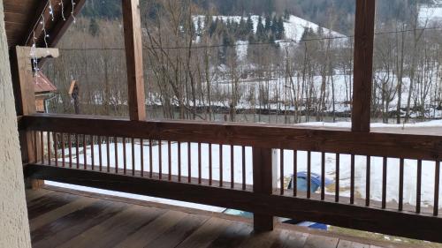 a view from the balcony of a cabin with a view of the snow covered trees at Casa Noastră in Vidra