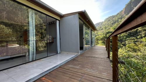 a house with a wooden deck with glass doors at CASA DINAMARCA in Santa Teresa