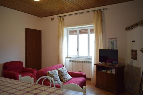 een slaapkamer met een bed, een tv en een stoel bij Guado di Pio-appartamento panoramico in Castelpetroso