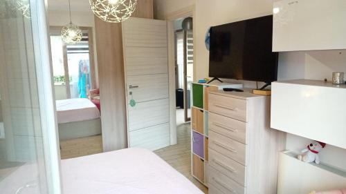 een woonkamer met een televisie en een slaapkamer bij Pomezia centro in Pomezia
