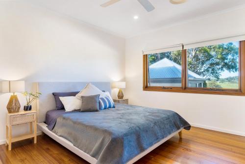 A bed or beds in a room at Byron Bay Hinterland Breeze 2bed & pool