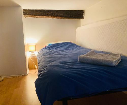 Ce lit se trouve dans un dortoir doté d'une couverture bleue. dans l'établissement Grand studio meublé et équipé plein centre, à Montpellier