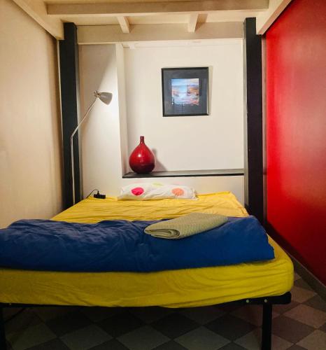 - une chambre avec un lit jaune et un mur rouge dans l'établissement Grand studio plein centre, à Montpellier
