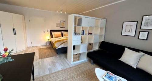 uma sala de estar com uma cama e um sofá preto em Gemütliche Ferienwohnung am Kurpark em Bad Camberg