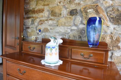 a wooden dresser with a blue vase on top of it at Casa Vacanze Il Cenito in Castellabate