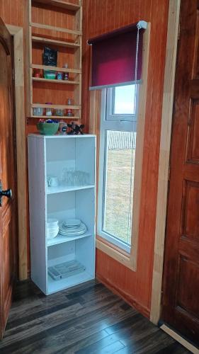 una nevera blanca en una habitación con ventana en Tyni house en Puerto Natales