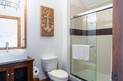 La salle de bains est pourvue de toilettes et d'une douche en verre. dans l'établissement La petite saisonnière, à Mont-Tremblant
