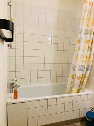 La salle de bains est pourvue d'une baignoire et d'un rideau de douche. dans l'établissement Grand studio plein centre, à Montpellier