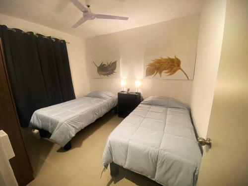 una camera da letto con due letti e un ventilatore a soffitto di Departamento En Bahía de Banderas a Conchas