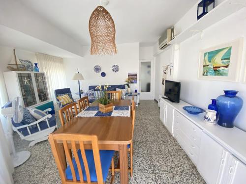 a kitchen with a dining table and a living room at Apartamento familiar a 200m de la playa in Alcossebre