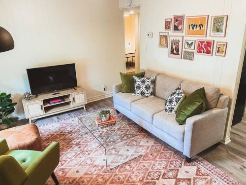 uma sala de estar com um sofá e uma televisão de ecrã plano em Artist's Bungalow - 1/2 mi from Covington Square em Covington