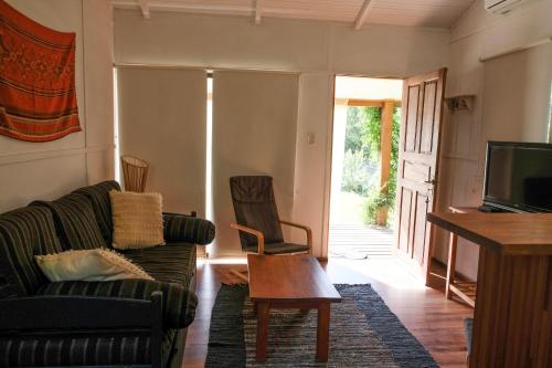 uma sala de estar com um sofá e uma televisão em Las cabañas de macarena em Punta del Este