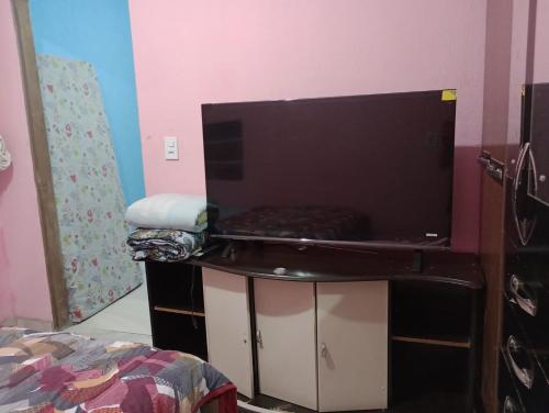 a room with a table with a bed and a tv at Apartamento Acochegante in Manaus
