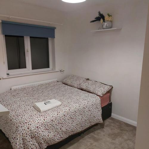 a bedroom with a bed and a window with a white at Double room in a cul de sac area in Wellingborough