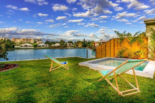 a yard with two chairs and a swimming pool at Blue Lagoon Villas in Trinity Beach
