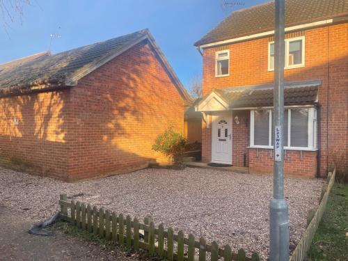 a brick house with a white door and a fence at 231 Senwick drive in Wellingborough