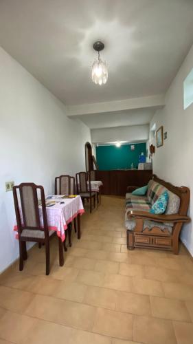 a living room with a table and chairs and a dining room at Pousada Recanto da Giovana in Campos do Jordão