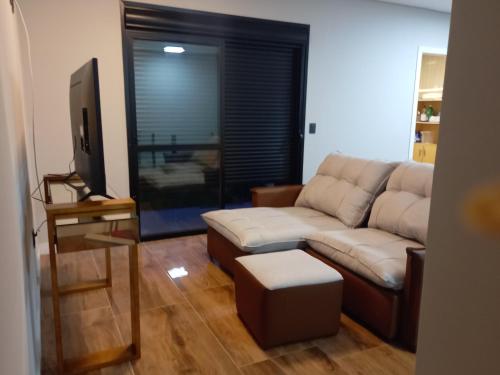 a living room with a couch and a tv at Casa 500 metros do mar in Florianópolis