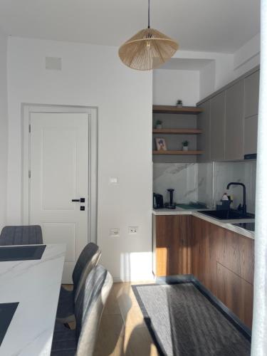 a kitchen with a table and some chairs in a room at Sunny City Center Apartment in Lezhë