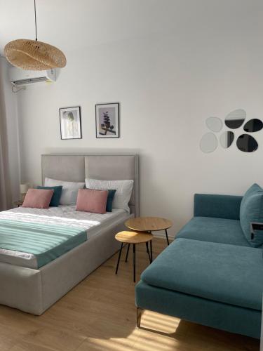 a bed and a couch in a room at Sunny City Center Apartment in Lezhë