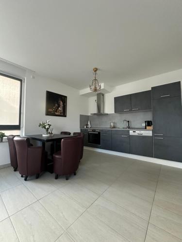 a kitchen with a table and chairs in a room at Temporalis Unterkunft in Langerwehe