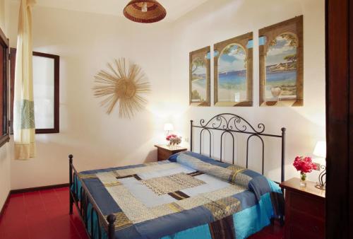a bedroom with a bed with a blue comforter at Pinus Village Appartamento in Santa Margherita di Pula