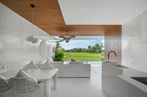 a kitchen with a white table and chairs and a pool at GREEN FlOW Villas Ubud II in Ubud