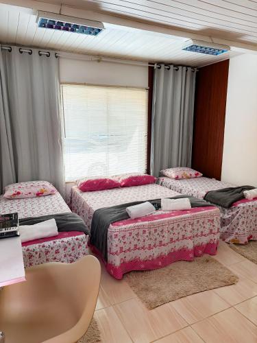 sypialnia z 3 łóżkami i oknem w obiekcie Hostel das Flores w mieście Belém