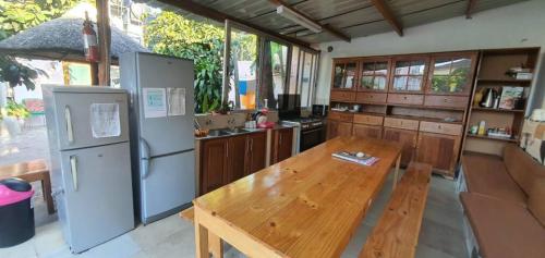 a kitchen with a wooden table and a refrigerator at Kaya Lethu in Maputo