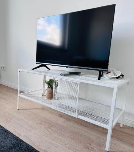 un televisor en un puesto blanco con un televisor en él en Doppelzimmer, en Lübeck