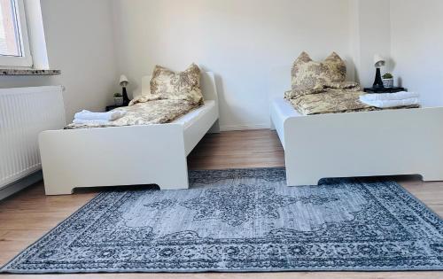 dois sofás brancos numa sala de estar com um tapete em Doppelzimmer em Lübeck