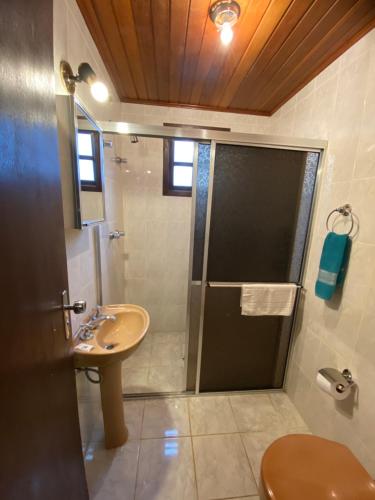 a bathroom with a shower and a sink at Pousada Recanto da Giovana in Campos do Jordão