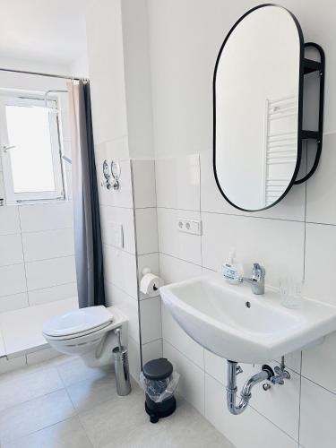 Baño blanco con lavabo y aseo en Doppelzimmer, en Lübeck