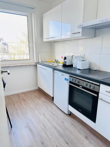 uma cozinha com electrodomésticos brancos e uma janela em Doppelzimmer em Lübeck