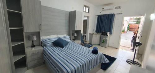 a bedroom with a bed with blue pillows on it at Kaya Lethu in Maputo