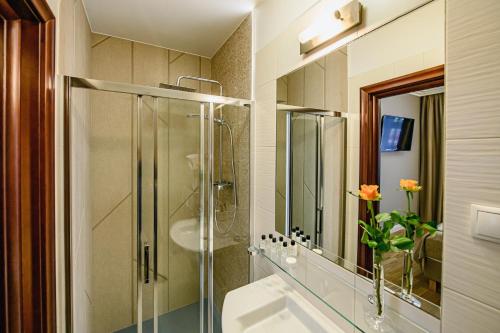 y baño con ducha acristalada y lavamanos. en Villa Neve, en Ustrzyki Dolne
